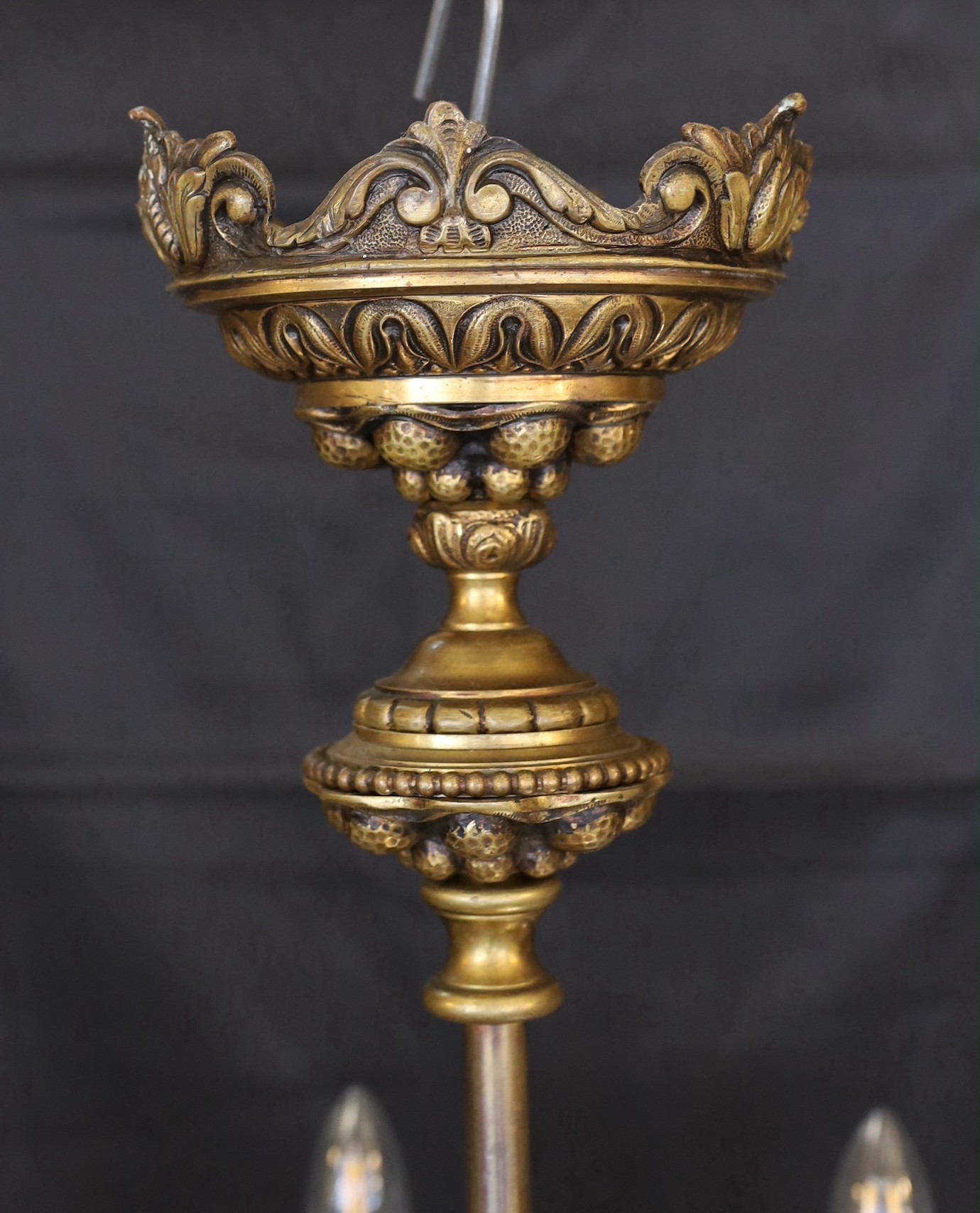 An early 20th Century Austrian bronze eight light chandelier, with scrolling branches and planished ball motifs, height 69cm. width 48cm